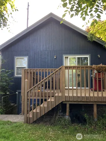a view of a house with wooden deck and furniture