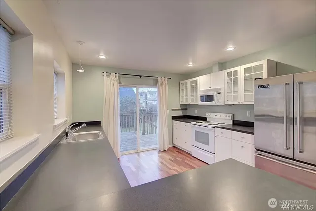 a kitchen with granite countertop a refrigerator and a sink