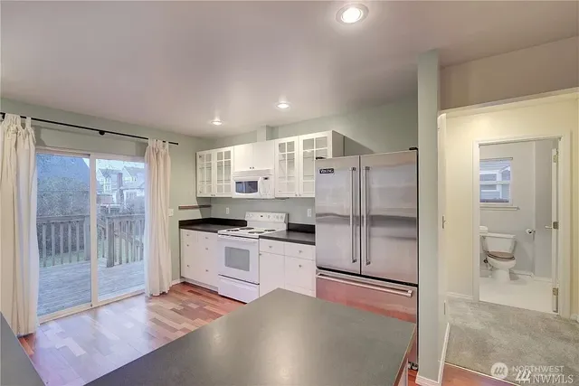 a kitchen with stainless steel appliances granite countertop a refrigerator and a stove top oven