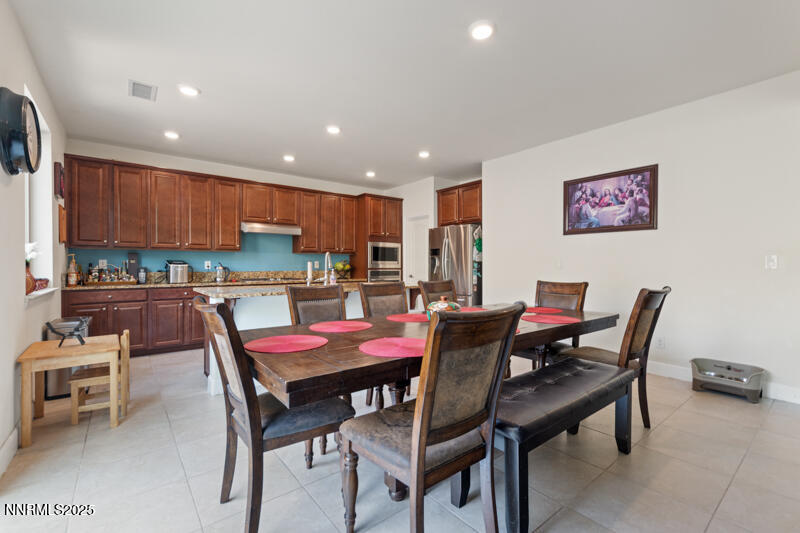 1590 Scott Valley Road Reno, NV 89523 - Photo 9 of 29 a kitchen with a dining table chairs and a refrigerator