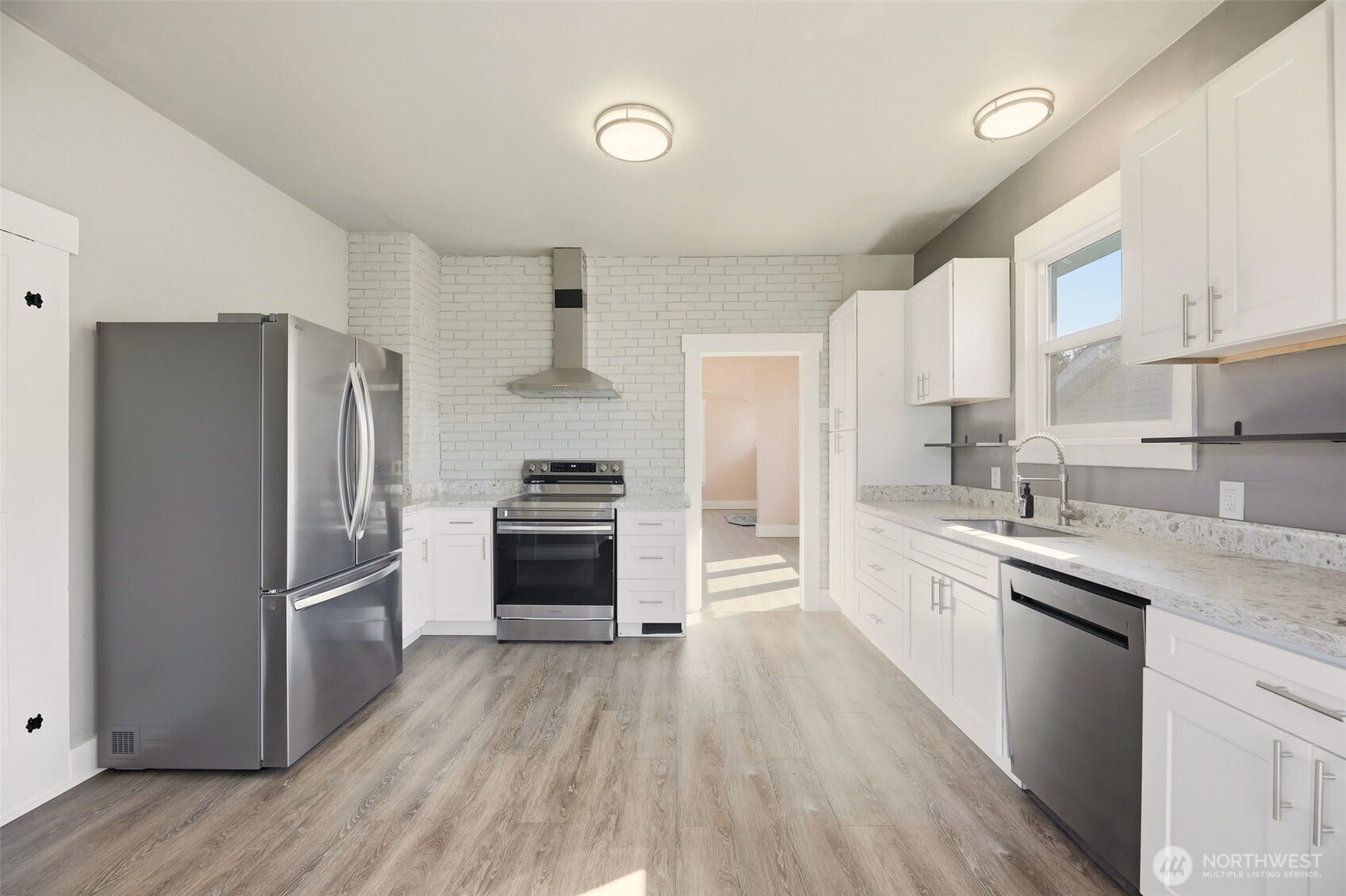 1726 Baker Avenue Everett, WA 98201 - Photo 17 of 39 a kitchen with granite countertop a refrigerator a sink dishwasher and a stove top oven with wooden floor