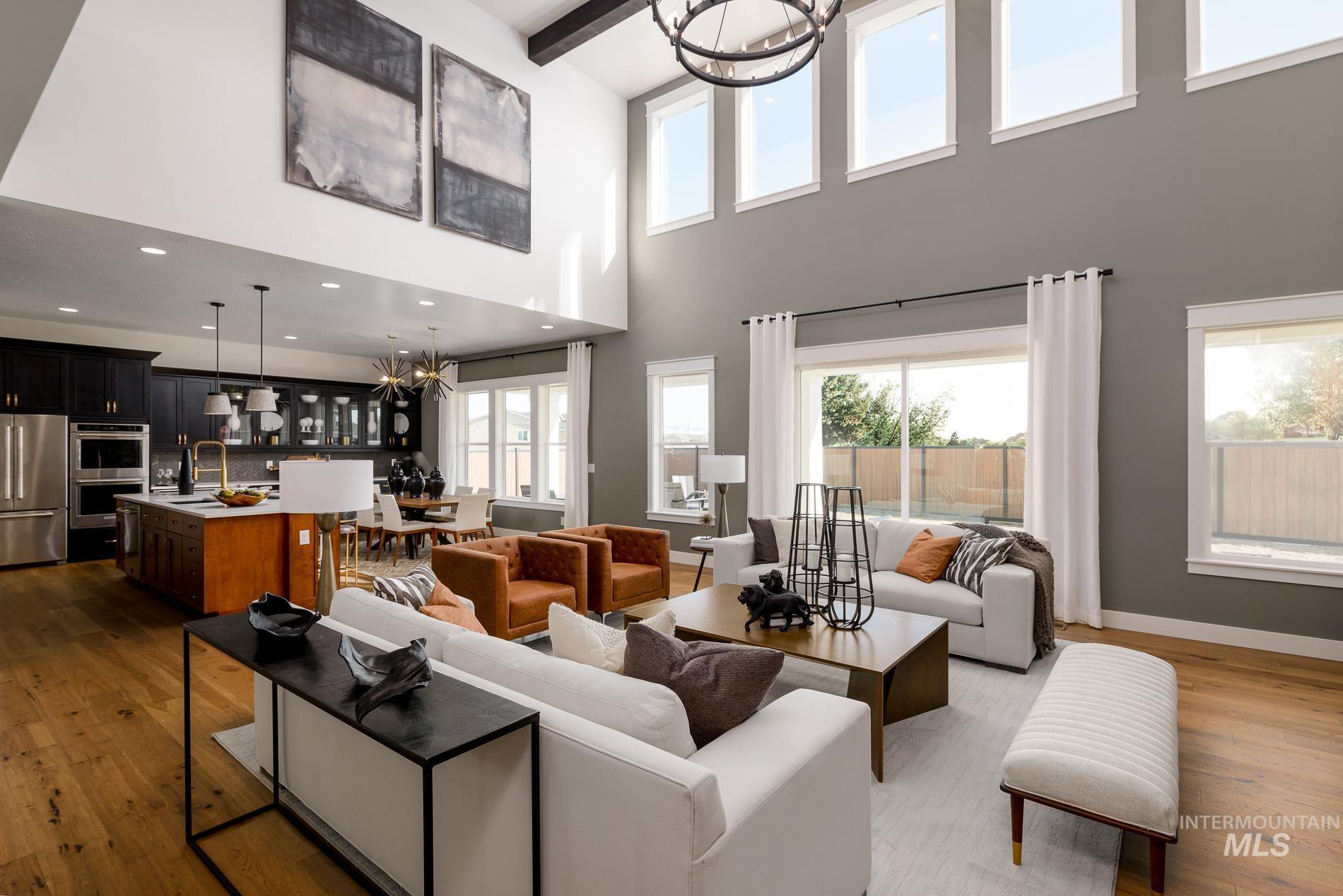 3370 North Del Sol Way Star, ID 83669 - Photo 3 of 30 Living room with suspended lighting, light wood-style floors, beam ceiling, and healthy amount of natural light