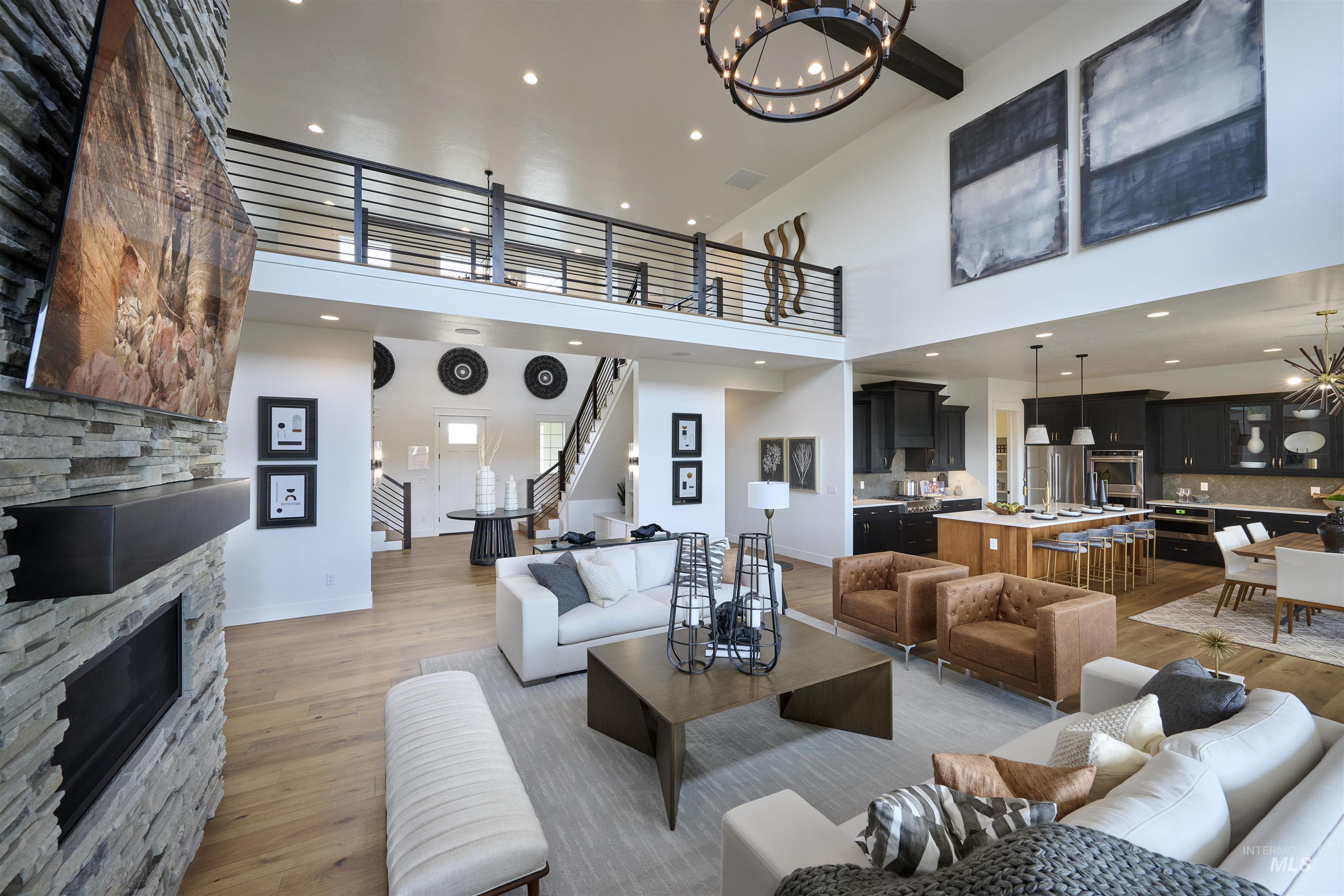 3370 North Del Sol Way Star, ID 83669 - Photo 4 of 30 Living room featuring hanging lights, a fireplace, light wood-style flooring, and a high ceiling