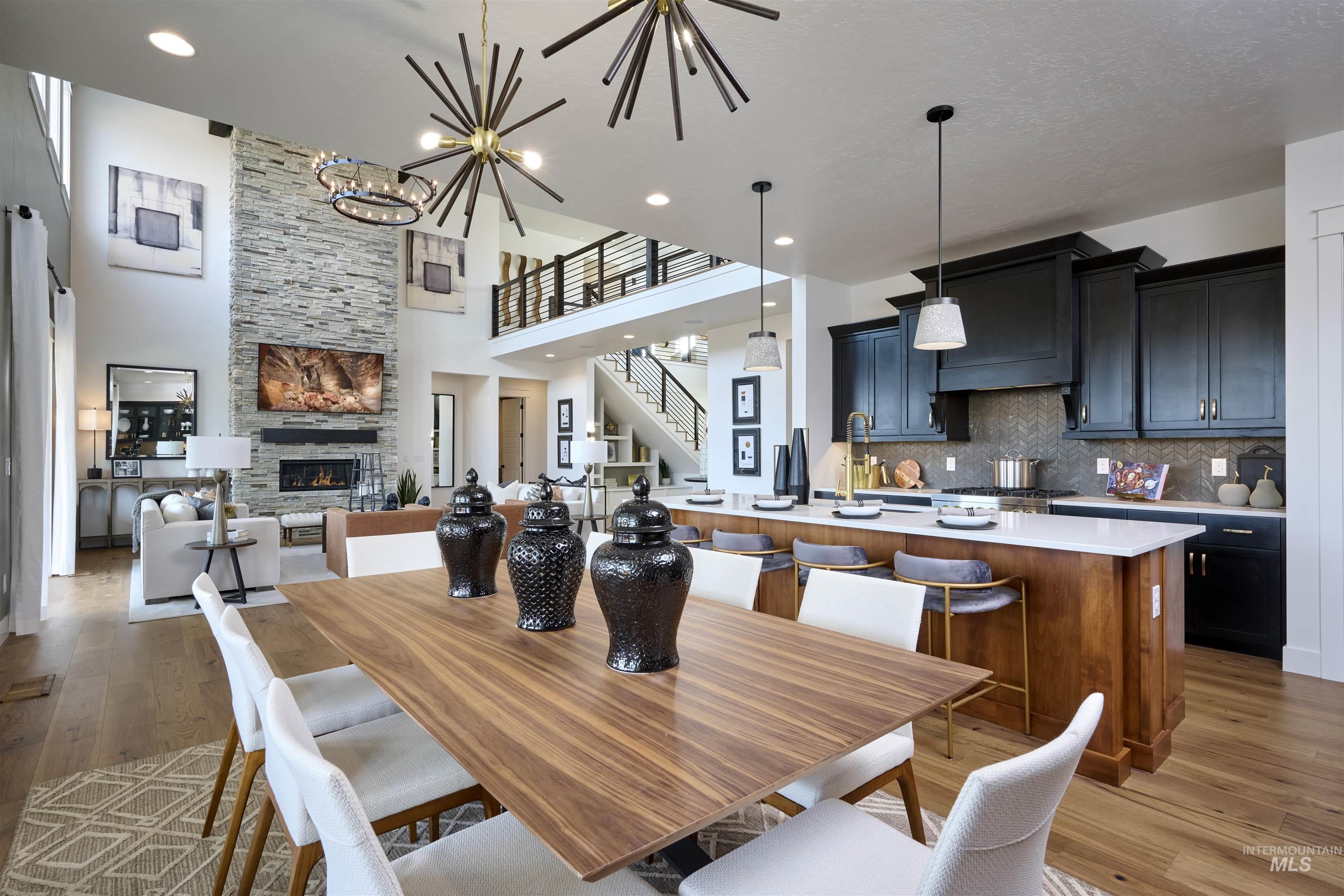 3370 North Del Sol Way Star, ID 83669 - Photo 6 of 30 Dining space featuring light wood-style flooring, a fireplace, a high ceiling, and a chandelier