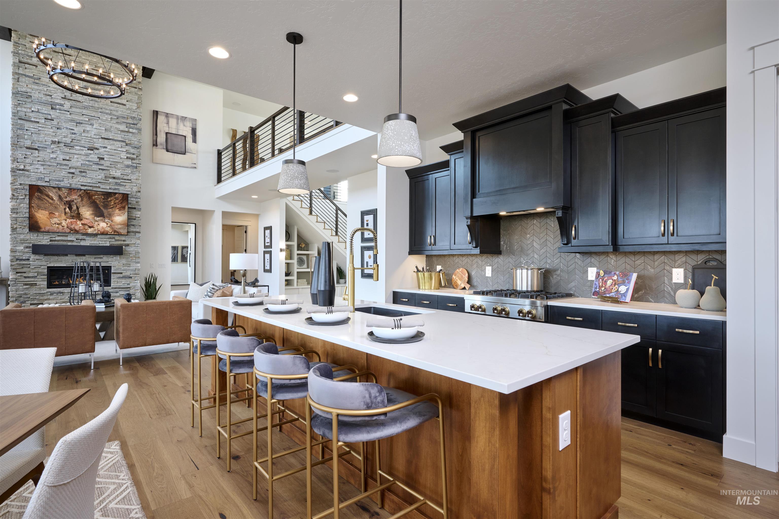 3370 North Del Sol Way Star, ID 83669 - Photo 30 of 30 Kitchen featuring open floor plan, a fireplace, dark cabinetry, a kitchen bar, and a center island with sink