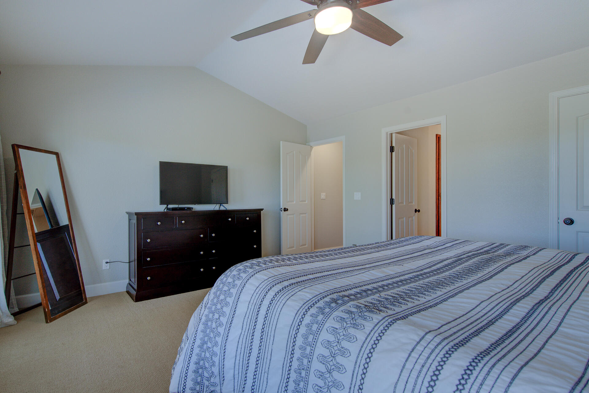 13416 Luna Drive Redding, CA 96003 - Photo 32 of 64 a bedroom with a bed and a flat tv screen on a dresser