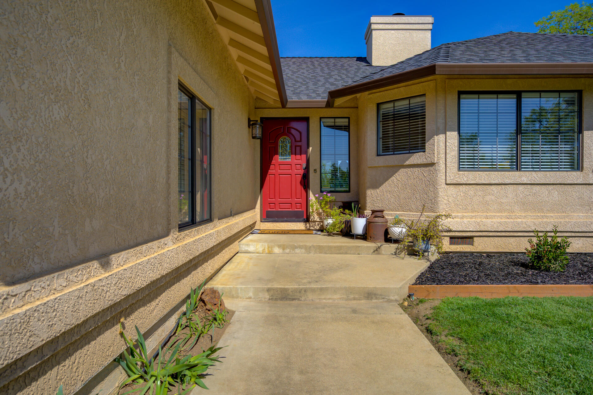 13416 Luna Drive Redding, CA 96003 - Photo 6 of 64 a view of a house with large windows and a small yard