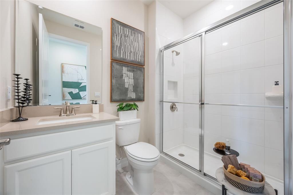 3973 Kennebunk Loop Mount Dora, FL 32757 - Photo 33 of 37 a bathroom with a granite countertop sink toilet a mirror and shower
