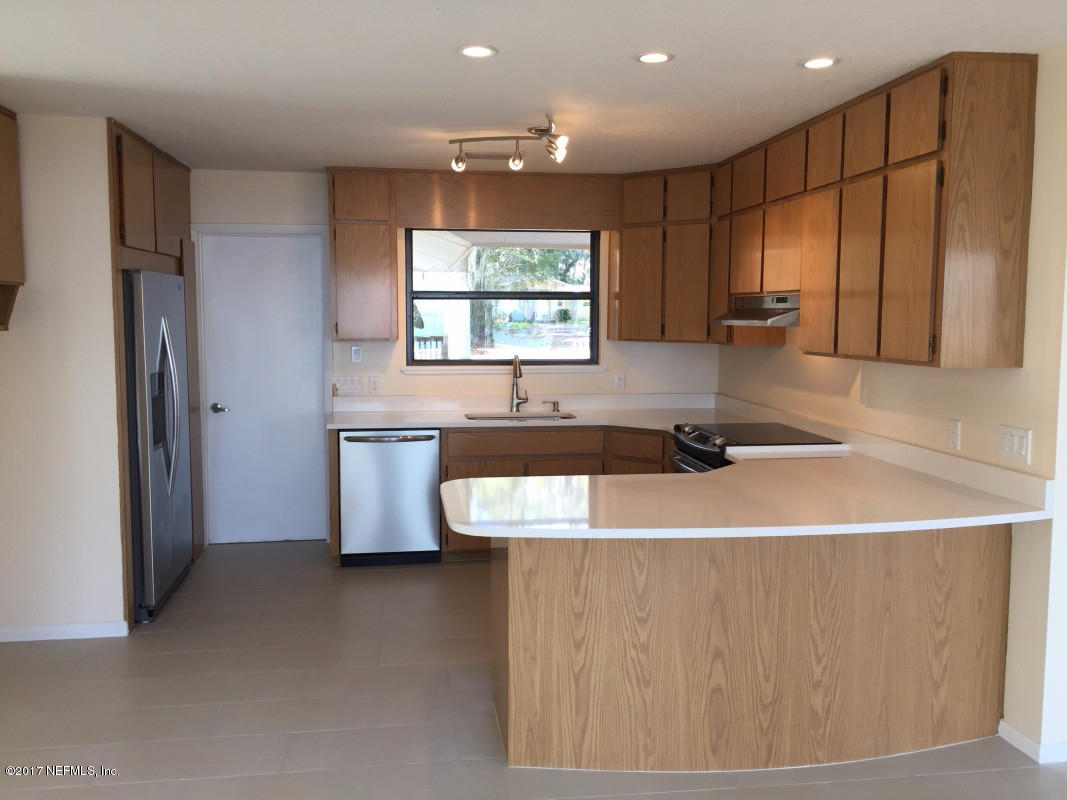 4127 Magnolia Road Orange Park, FL 32065 - Photo 10 of 24 a kitchen with kitchen island a sink a counter top space and stainless steel appliances