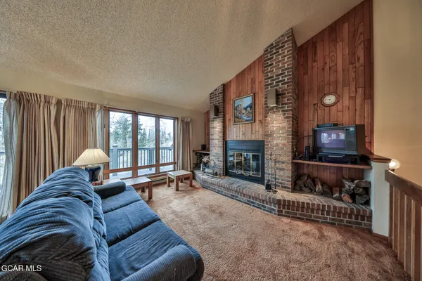 a living room with furniture a fireplace and a flat tv screen