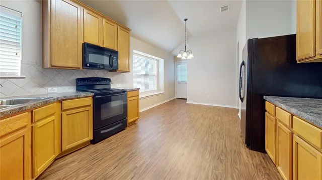 a kitchen with stainless steel appliances granite countertop a stove a sink and a microwave