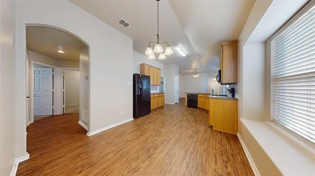 a view of a kitchen with cabinets and wooden floor