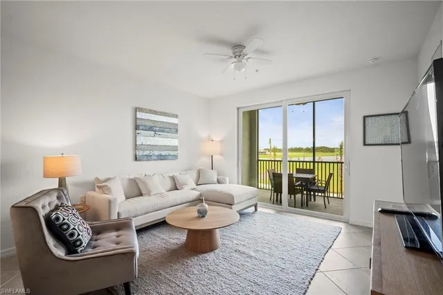 a living room with furniture and a floor to ceiling window