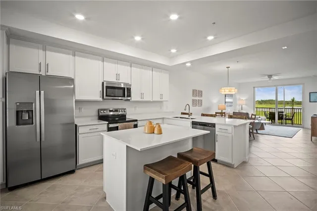 a kitchen view with stainless steel appliances a refrigerator a stove a sink dishwasher and a refrigerator with white cabinets