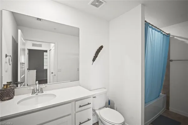 a bathroom with a granite countertop toilet sink and mirror
