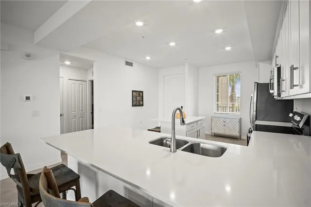 a kitchen with stainless steel appliances a sink and a refrigerator