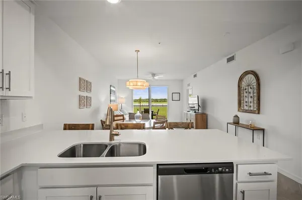 a kitchen with a sink a counter space and a refrigerator