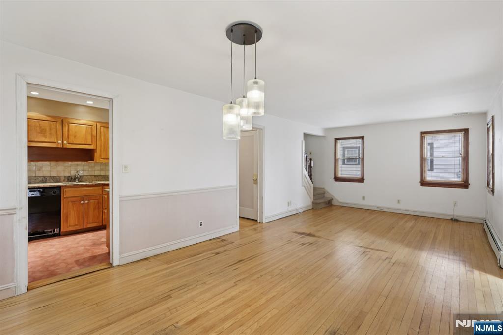 27 Jagoe Street Bergenfield, NJ 07621 - Photo 11 of 44 an empty room with wooden floor cabinet and windows