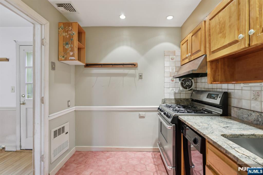 27 Jagoe Street Bergenfield, NJ 07621 - Photo 14 of 44 a kitchen with stainless steel appliances granite countertop a refrigerator and a stove
