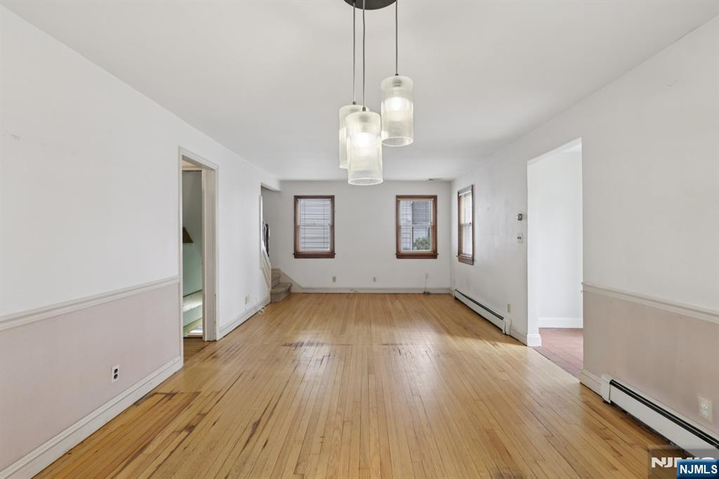 27 Jagoe Street Bergenfield, NJ 07621 - Photo 10 of 44 a view of an empty room with wooden floor and a window
