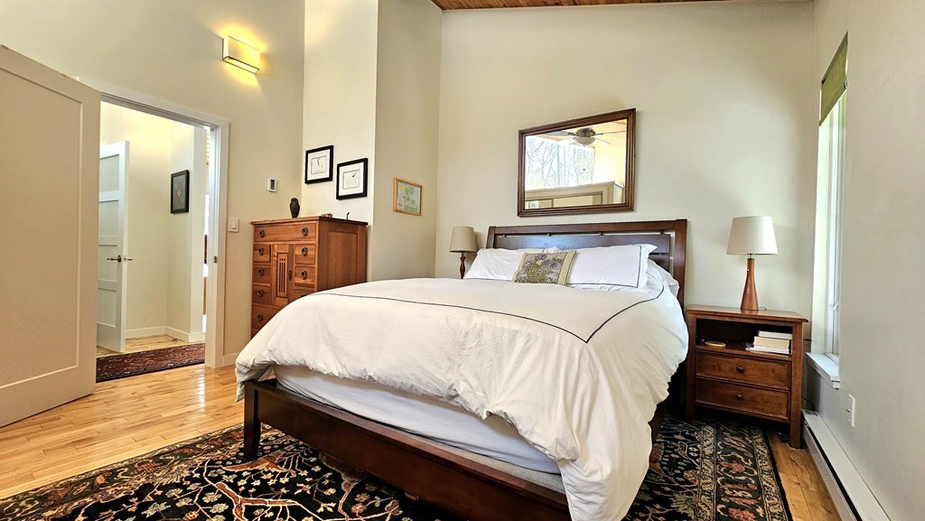28 Butterhill Road Pelham, MA 01002 - Photo 23 of 42 a bedroom with a bed and wooden floor