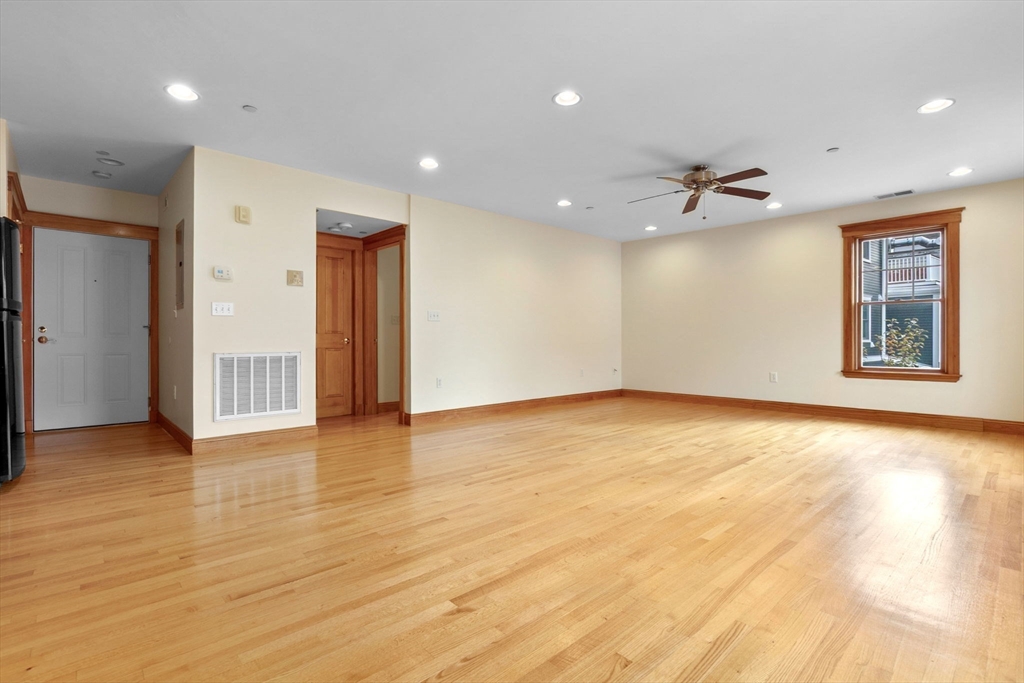 50 Maple Street, Unit 5 Danvers, MA 01923 - Photo 11 of 21 a view of an empty room with window and wooden floor