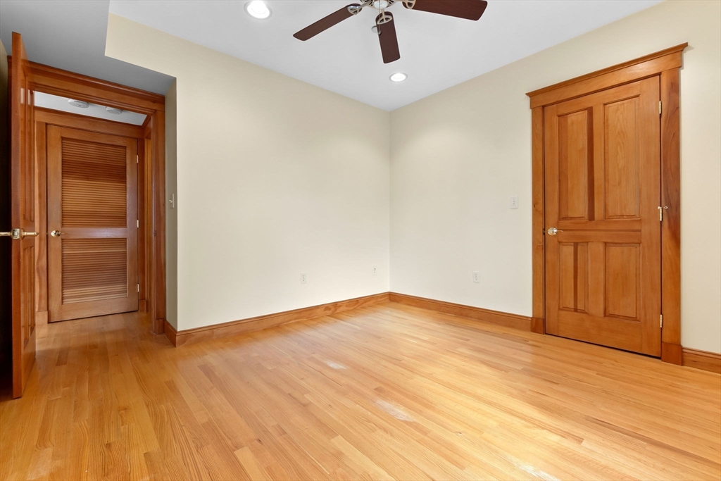 50 Maple Street, Unit 5 Danvers, MA 01923 - Photo 14 of 21 an empty room with wooden floor cabinet and windows