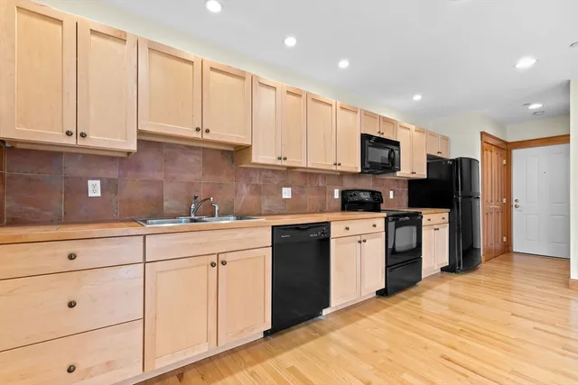 a kitchen with granite countertop white cabinets and stainless steel appliances