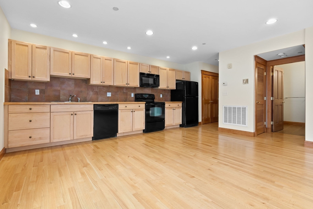 50 Maple Street, Unit 5 Danvers, MA 01923 - Photo 7 of 21 a large kitchen with stainless steel appliances granite countertop a stove a sink and a refrigerator