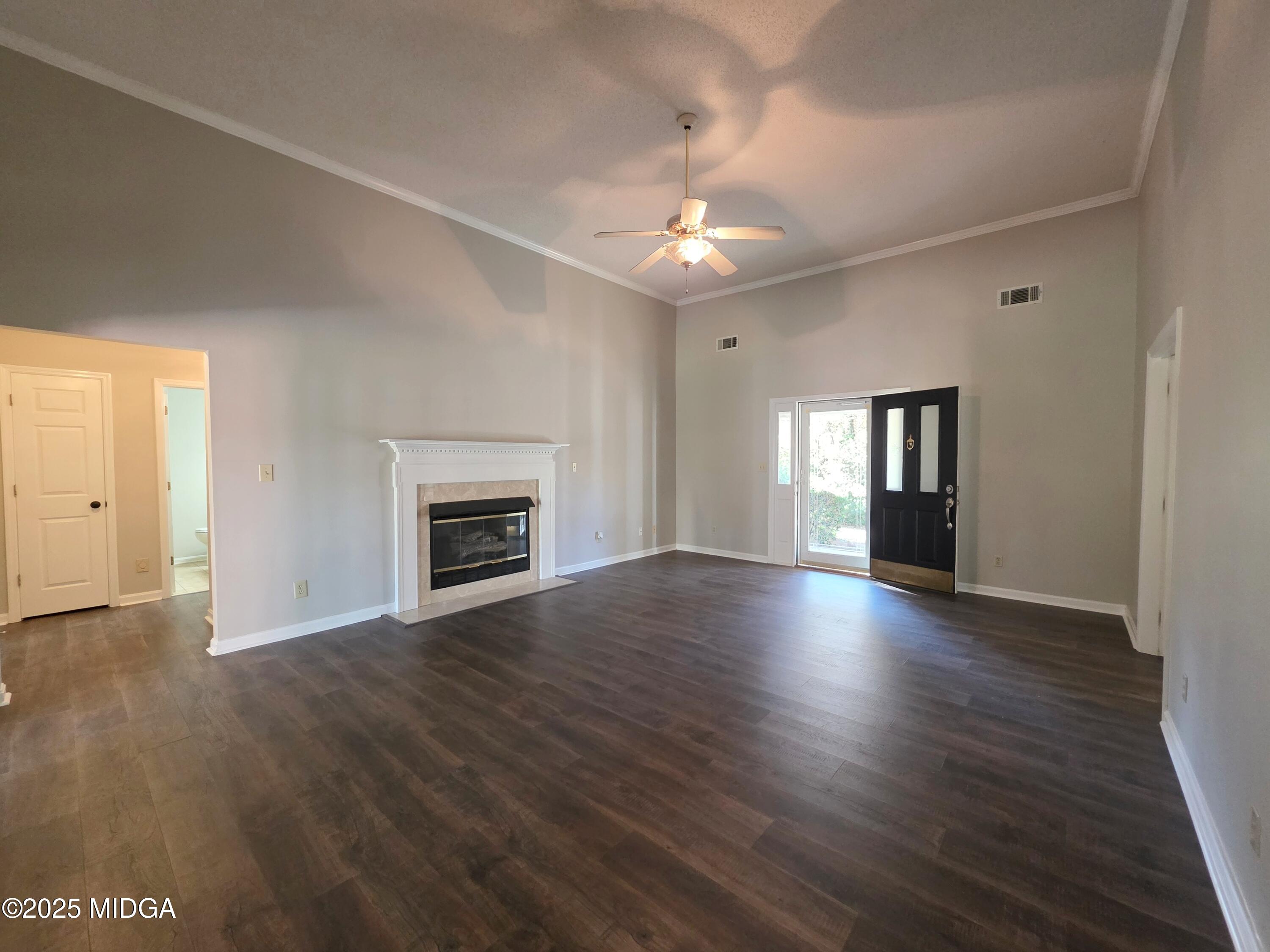 307 Pheasant Ridge Drive Warner Robins, GA 31088 - Photo 8 of 39 an empty room with wooden floor fireplace and windows
