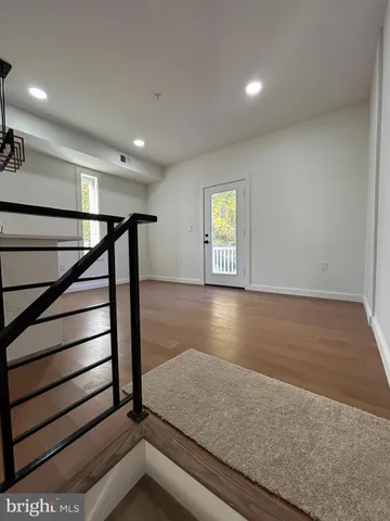 a kitchen with stainless steel appliances granite countertop a sink a refrigerator and a view of living room