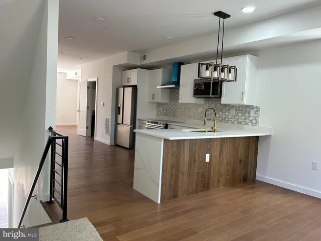 a large kitchen with a refrigerator stove and sink