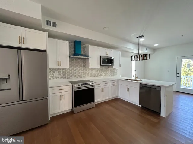 a view of a livingroom with wooden floor and stairs