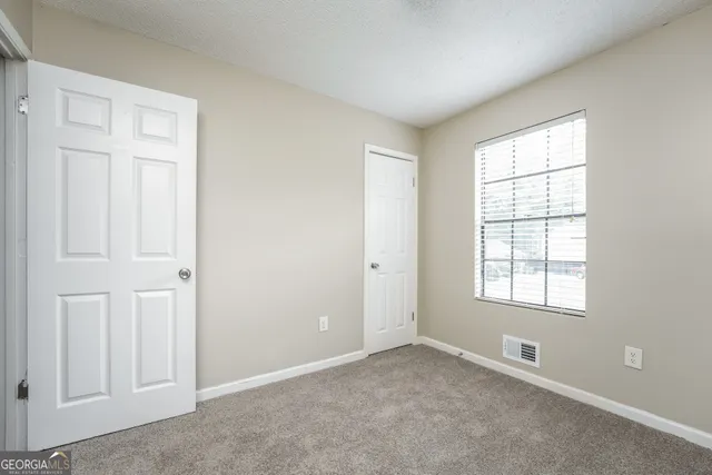 an empty room with a fireplace and windows