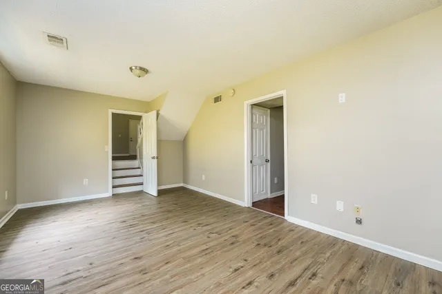 a view of a room with wooden floor and a window