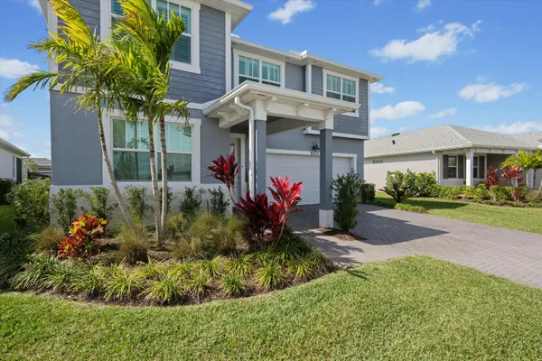 a front view of a house with a yard and potted plants