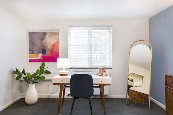 a view of a workspace with furniture and a potted plant