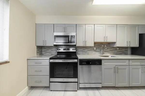 a kitchen with cabinets appliances and a sink