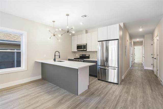 6110 Fillmore Place, Unit 1 West New York, NJ 07093 - Photo 3 of 7 a kitchen with refrigerator cabinets and wooden floor
