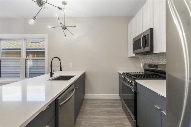 6110 Fillmore Place, Unit 1 West New York, NJ 07093 - Photo 4 of 7 a kitchen with stainless steel appliances granite countertop a sink stove and microwave