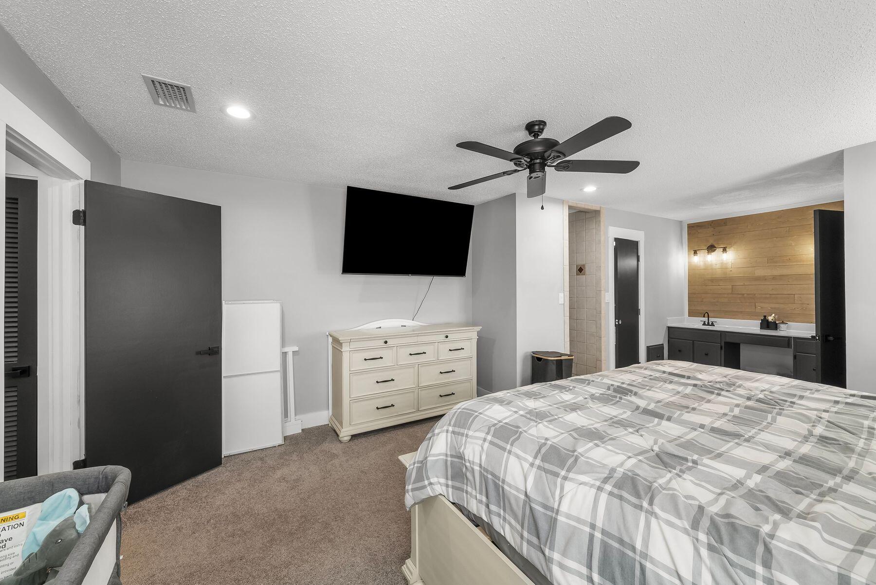 1218 Tuscany Road Panama City, FL 32405 - Photo 18 of 34 a bedroom with a bed and a flat screen tv