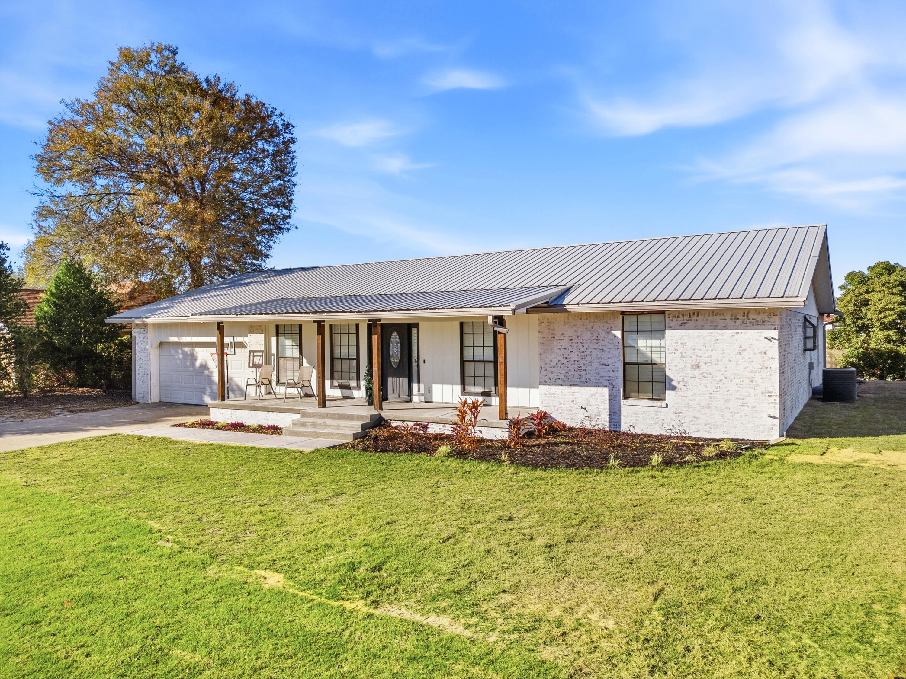 1218 Tuscany Road Panama City, FL 32405 - Photo 2 of 34 a front view of a house with a garden and trees