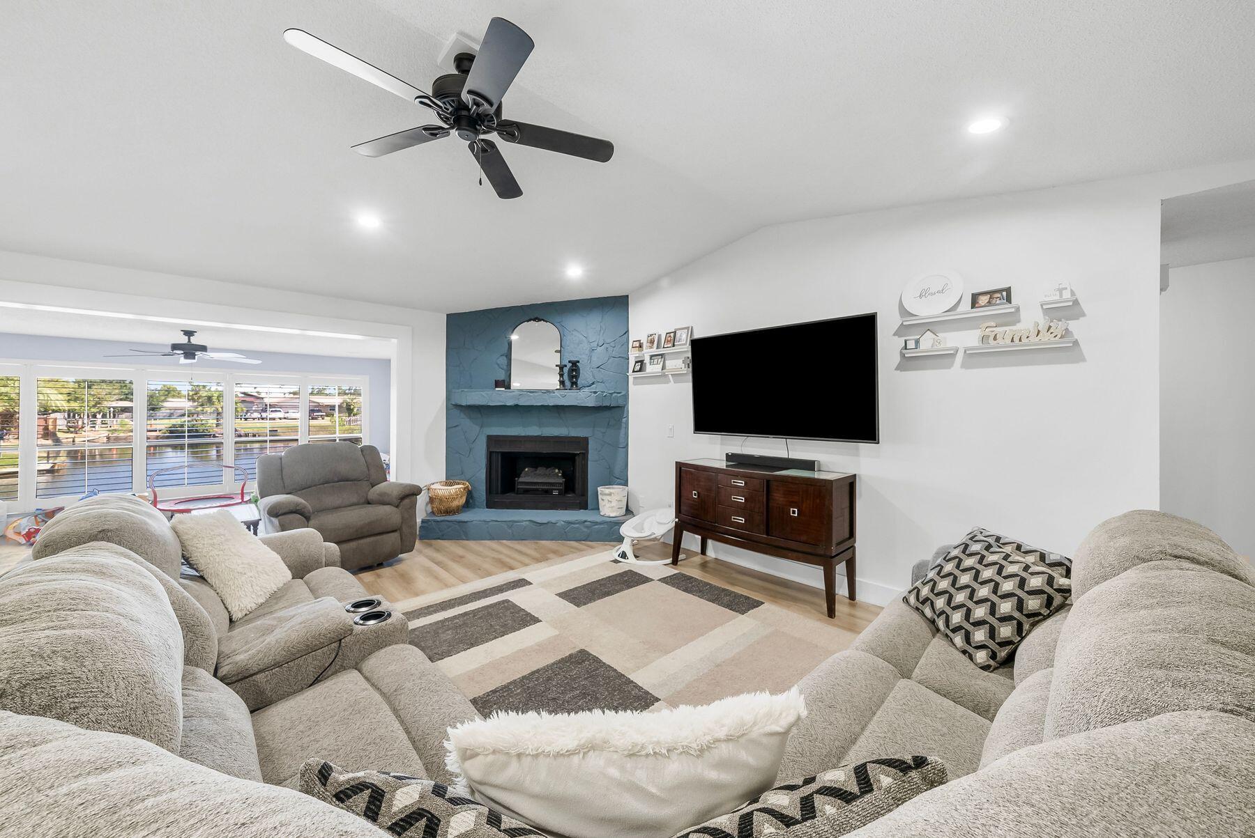 1218 Tuscany Road Panama City, FL 32405 - Photo 5 of 34 a living room with furniture a flat screen tv and a fireplace