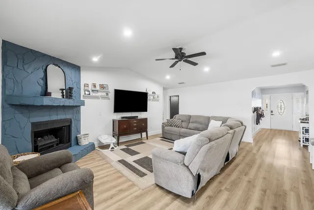 a living room with furniture a flat screen tv and a fireplace