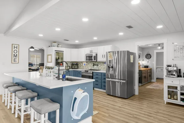 a kitchen with refrigerator and chairs