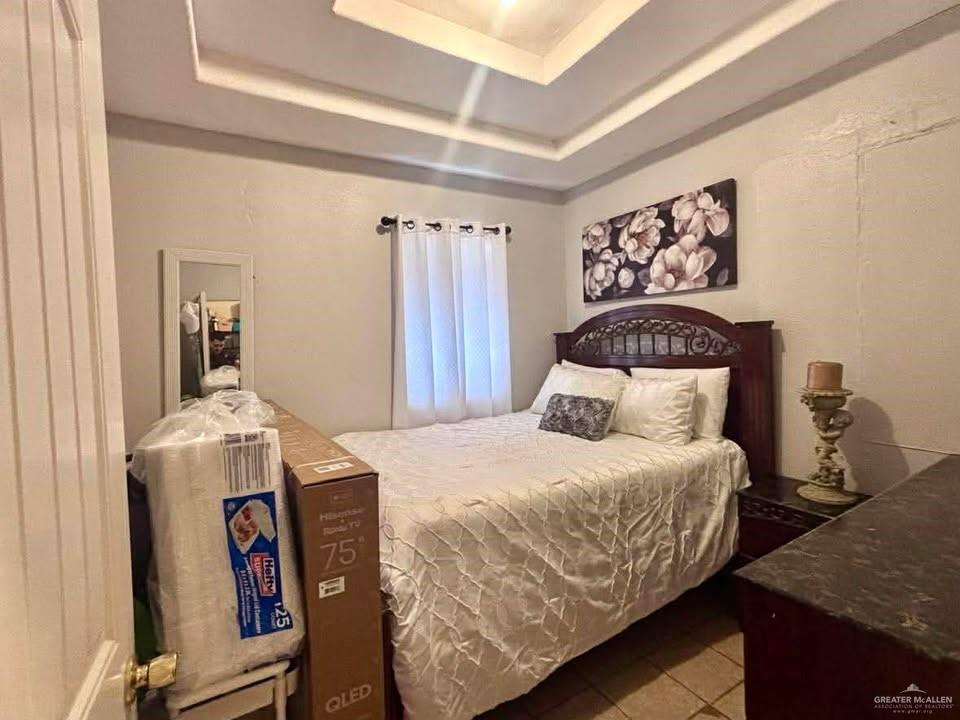 3113 Pradera Street Mission, TX 78574 - Photo 12 of 20 a bedroom with a bed and a chandelier