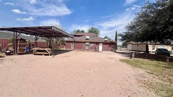 a view of a back yard with a table and chairs under an umbrella