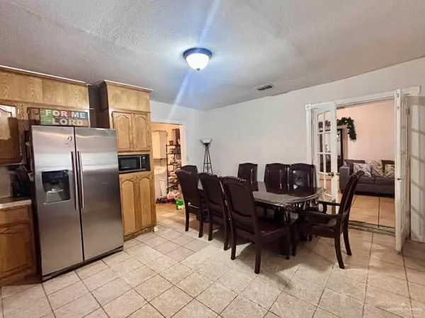 a kitchen with stainless steel appliances a table chairs and a refrigerator