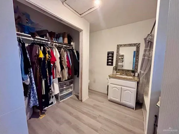 a view of walk in closet with clothes and shoes