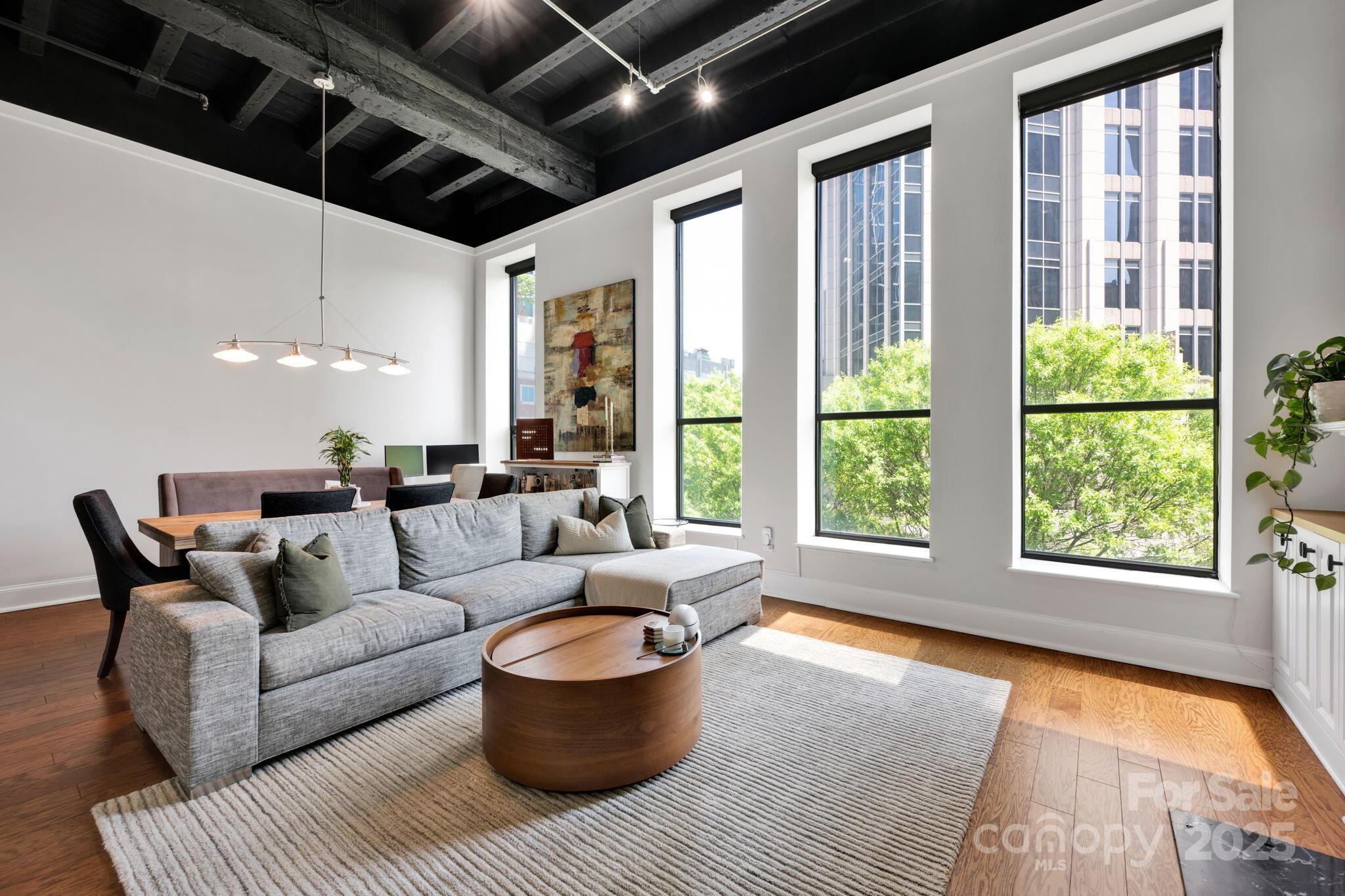 127 North Tryon Street, Unit 404 Charlotte, NC 28246 - Photo 12 of 22 a living room with furniture and a large window